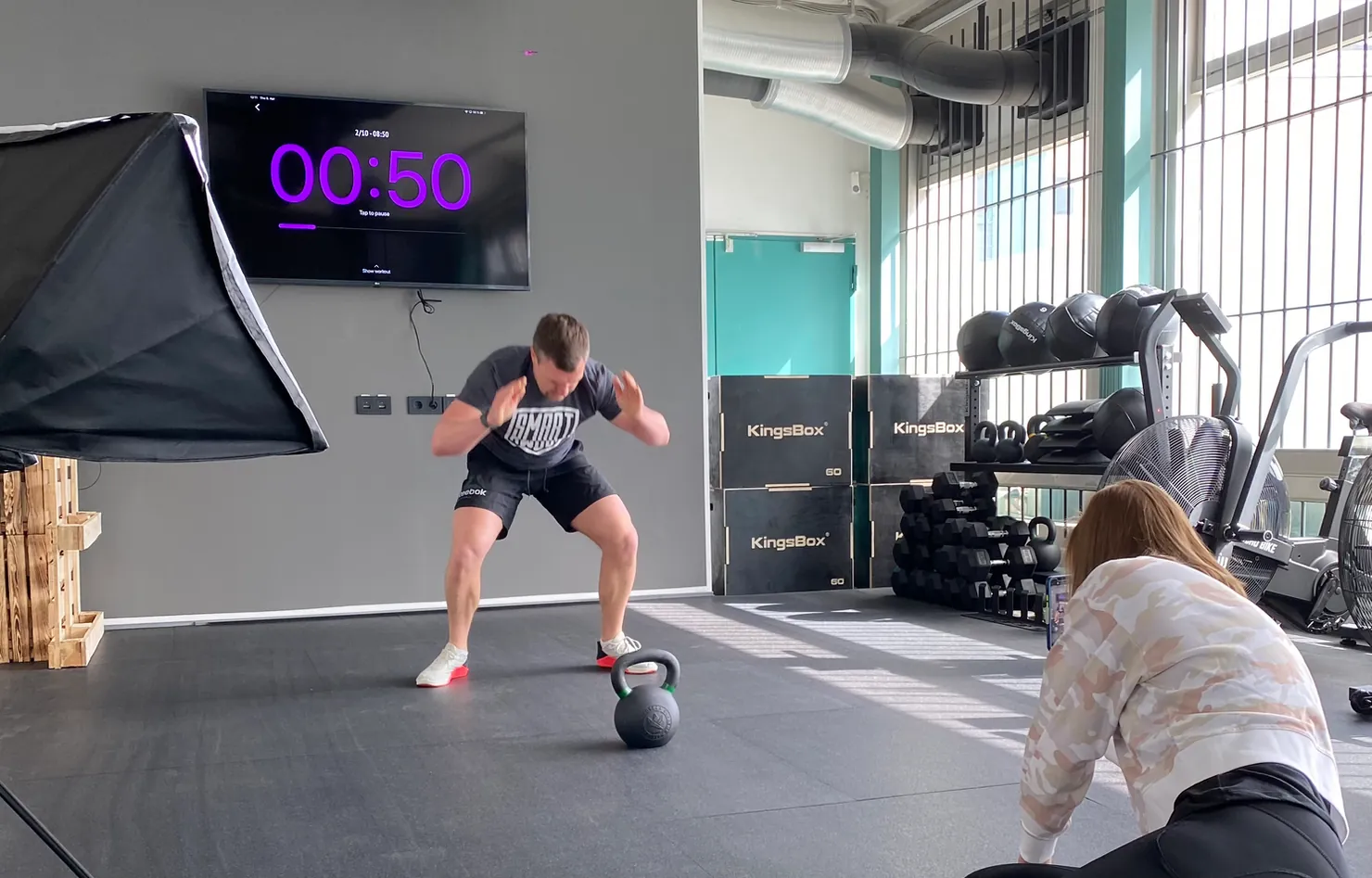 Athlete training with the SmartWOD timer in the background