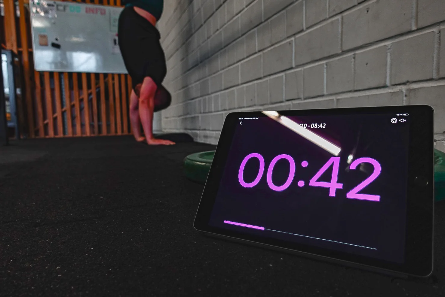 Athlet, der mit einem Timer Handstand macht