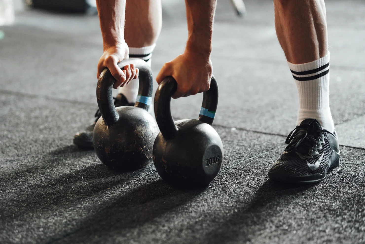 Athlet, der zwei Kettlebells hält