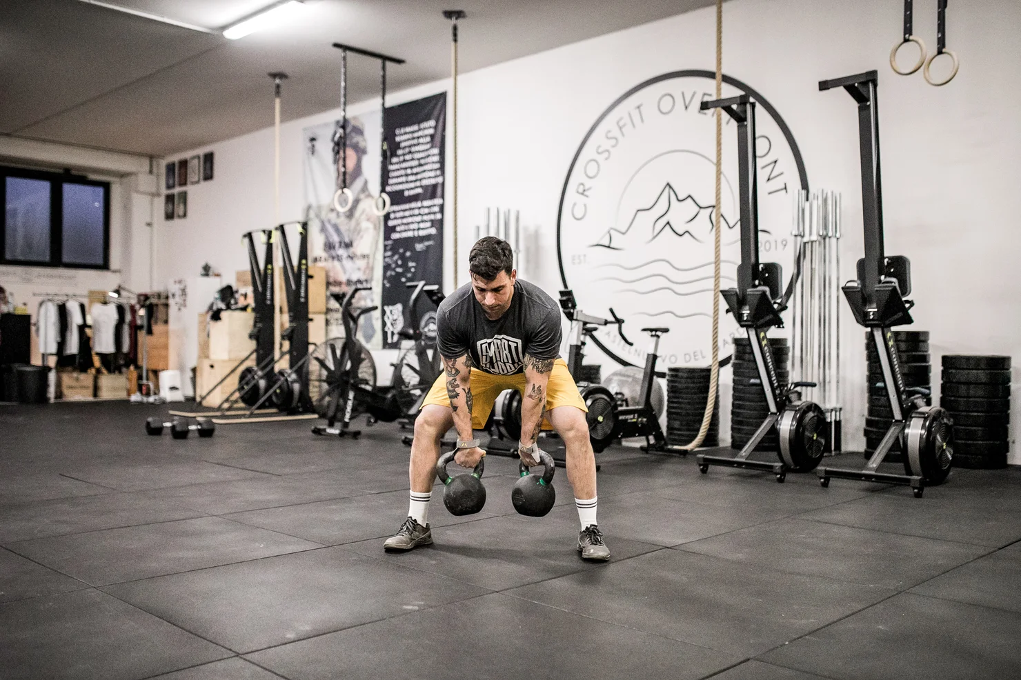 Sportler, der mit zwei Kettlebells trainiert