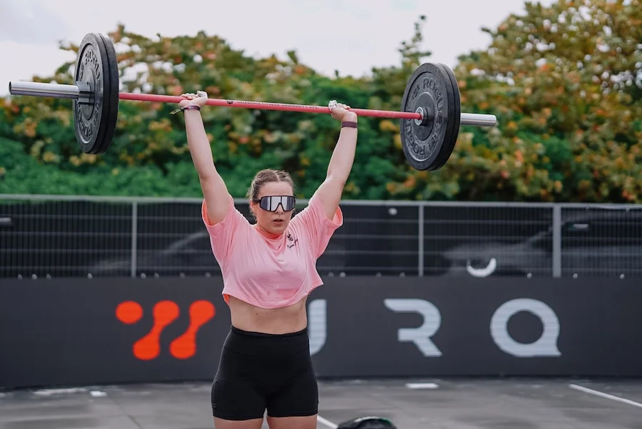 Athletin mit einer Langhantel und RX-Gewichten