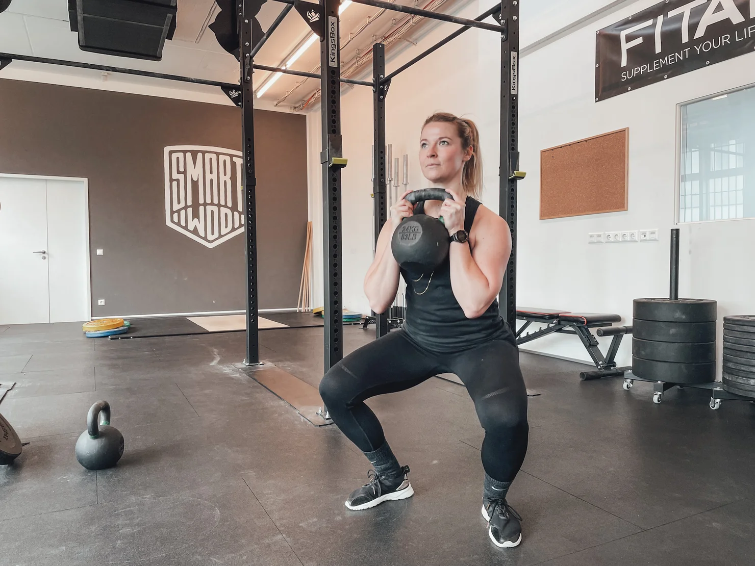 Athletin bei einem Goblet Squat mit der Kettlebell