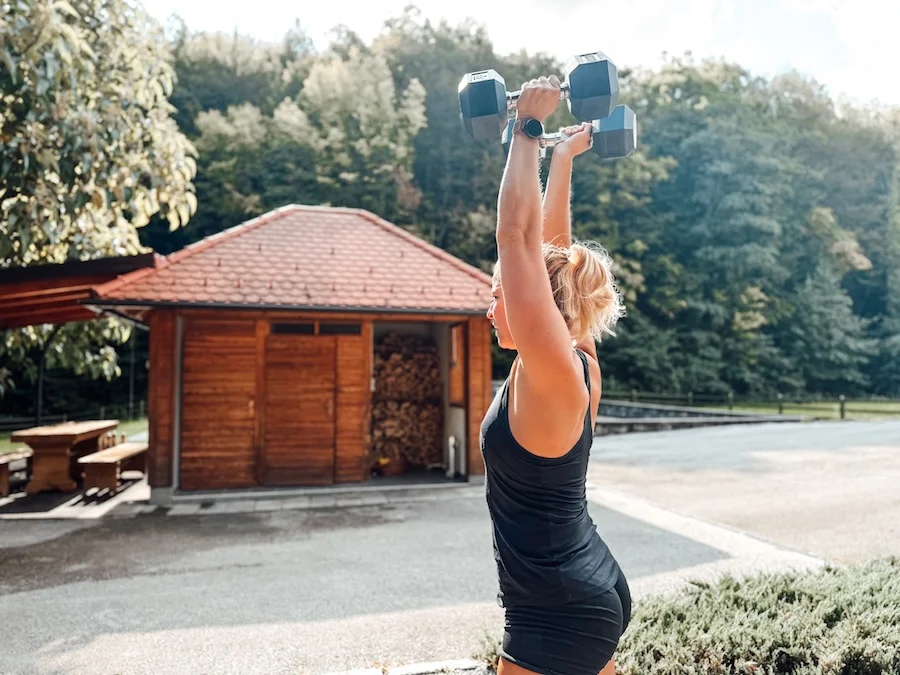 Athletin bei einem Push Press mit Kurzhanteln