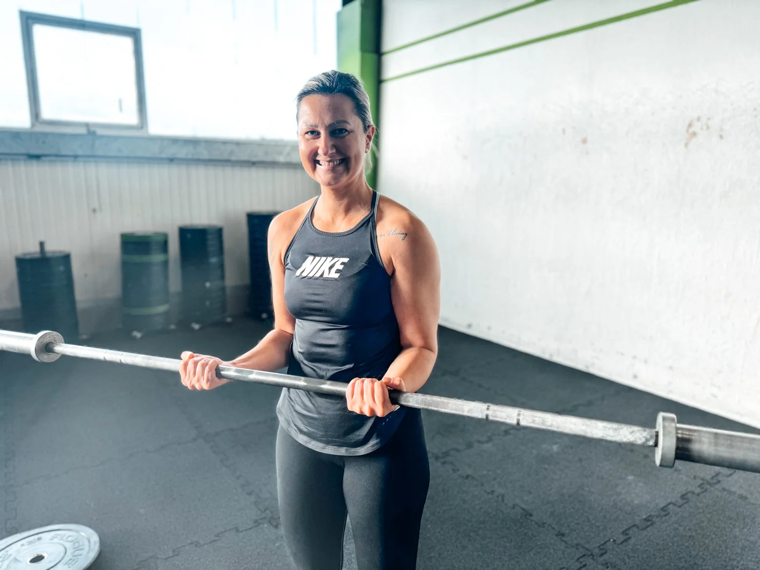Athletin, die mit einer Langhantel Bizeps trainiert