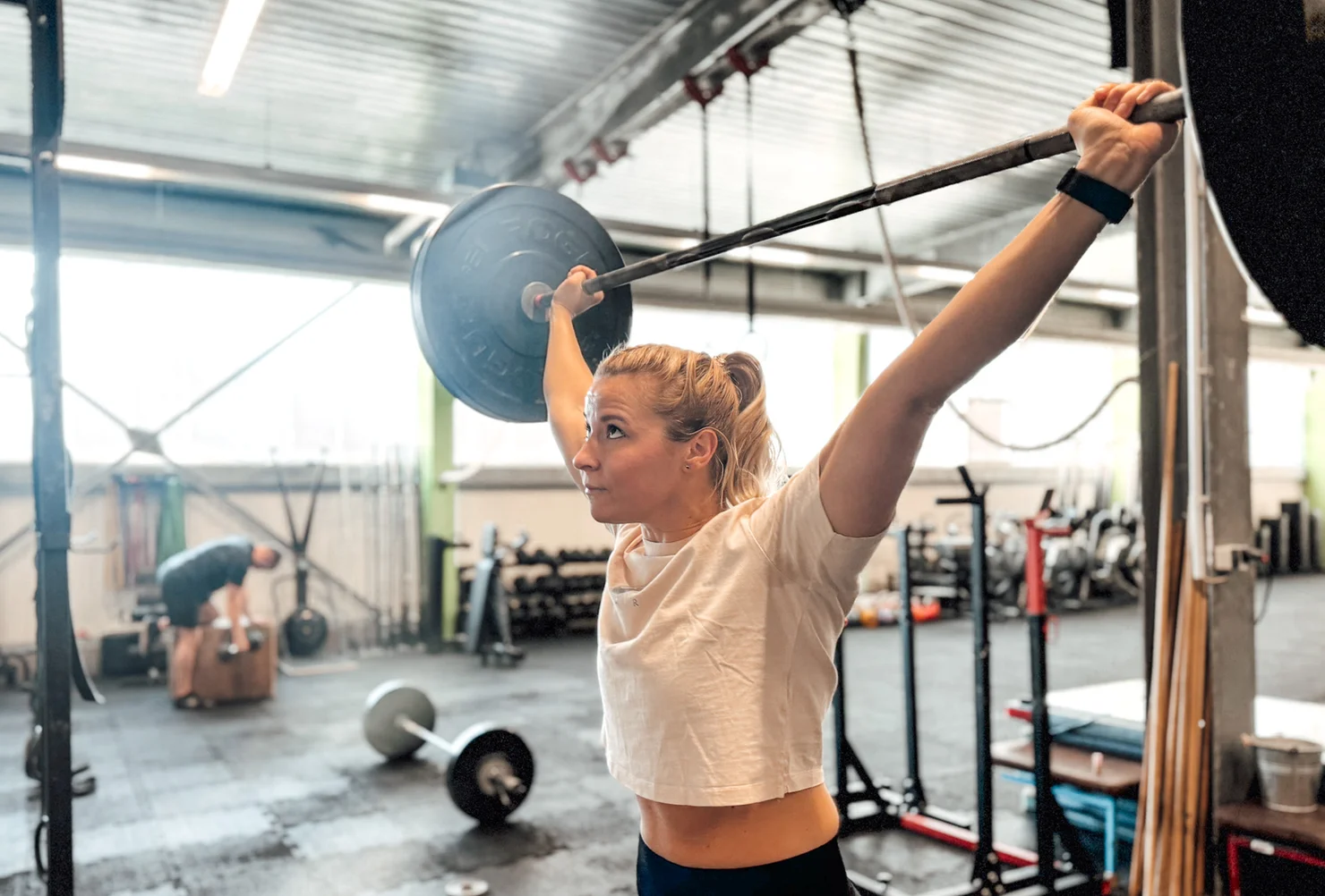 Athletin, die mit einer Langhantel Überkopf trainiert