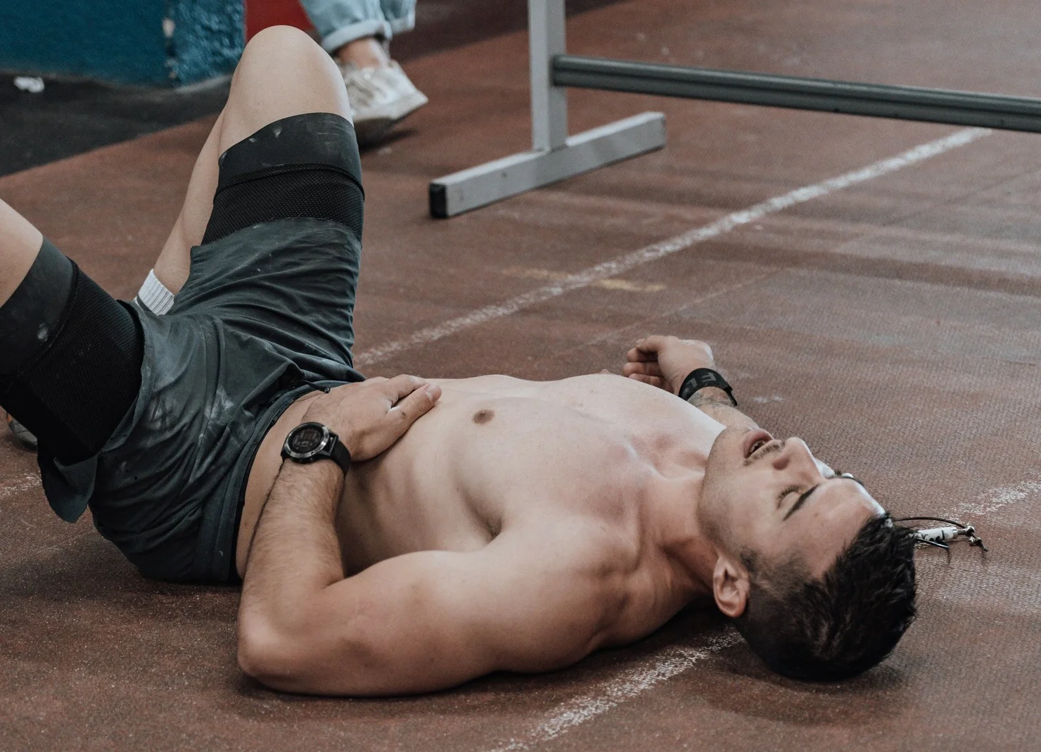 CrossFit Athlet, der nach einem Workout verschwitzt auf dem Boden liegt