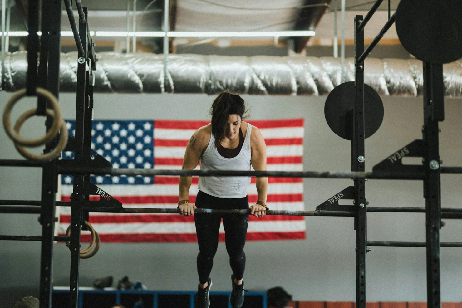 CrossFit-Athletin, die einen Bar Muscle-up macht