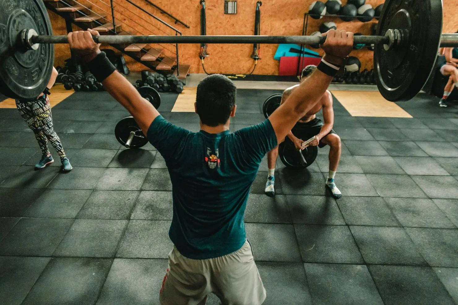 CrossFit Athlet, der in einer CrossFit Box mit einer Langhantel trainiert.