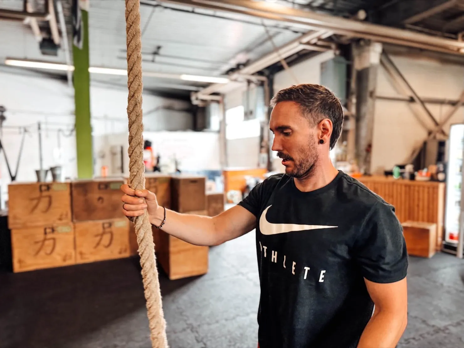 Athlet steht am Kletterseil in einer CrossFit-Box