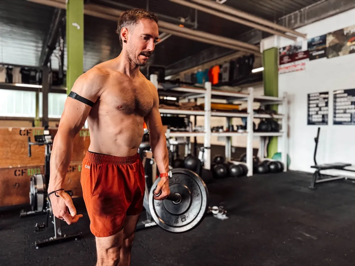 Athlet trägt eine Hantelscheibe durchs Gym