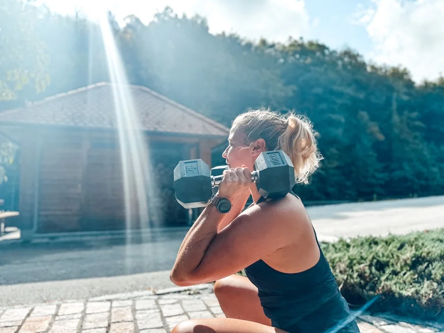 Frau mit zwei Kurzhanteln im Squat