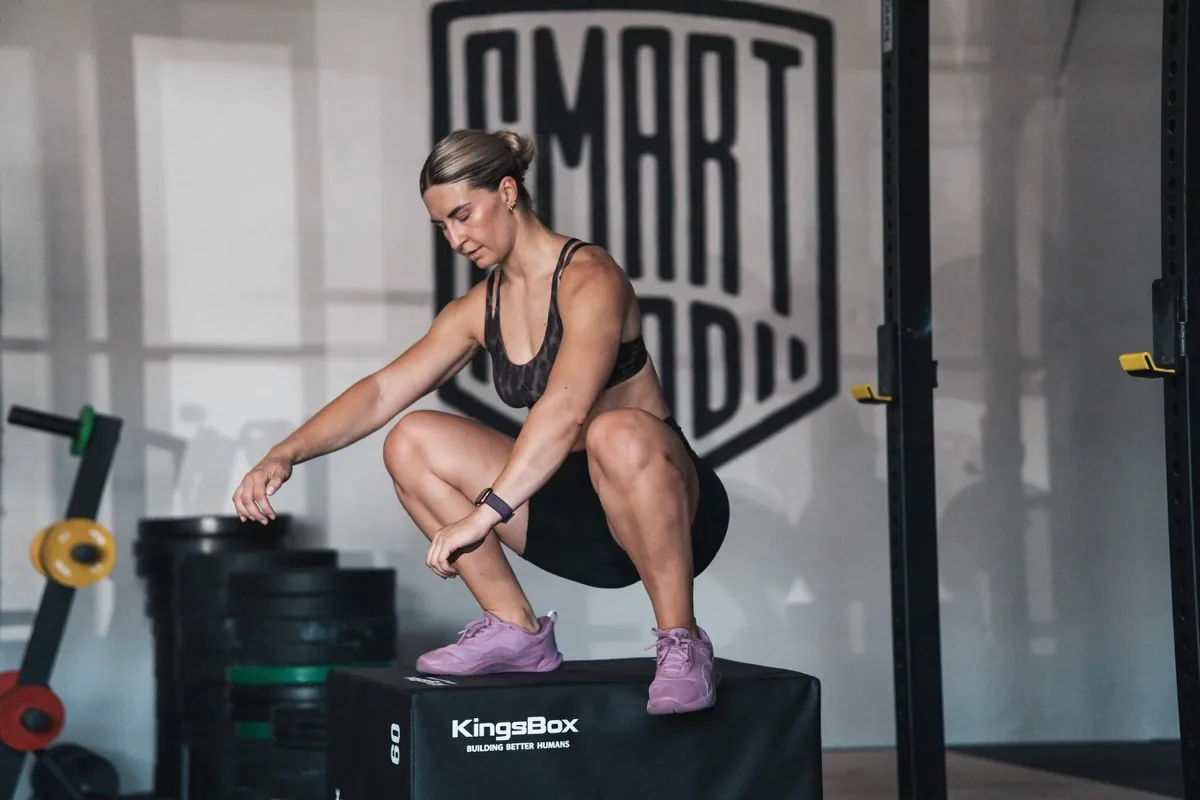 Athlete crouching on top of a plyo box in the gym