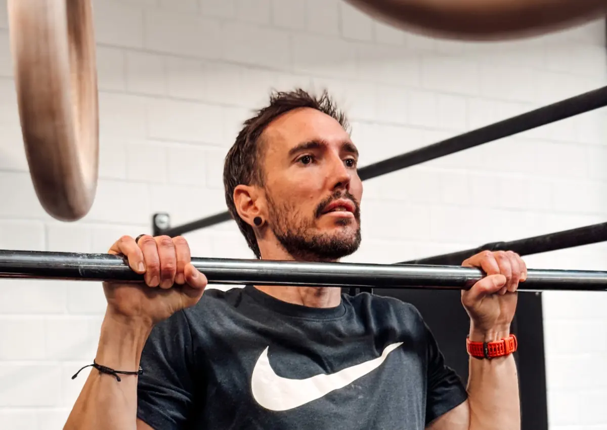 Athlete holding the top position of a pull-up with the chin at bar height