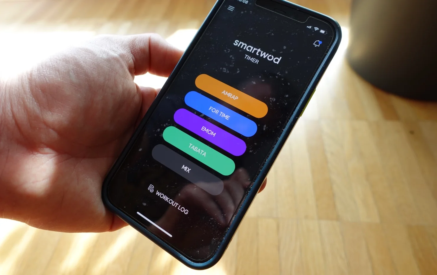 Person holding a smartphone with the SmartWOD timer open
