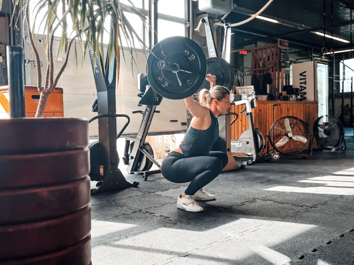 Athlete in the bottom position of a barbell overhead squat in the gym