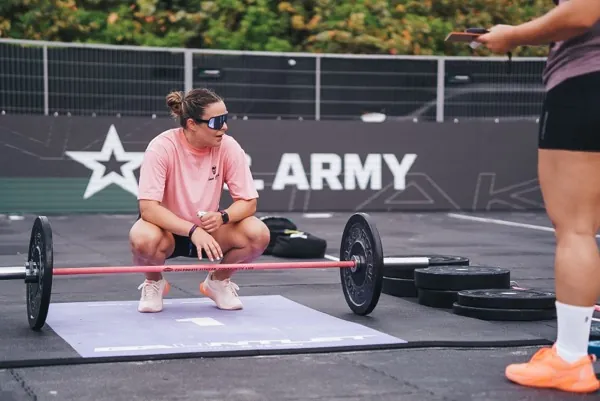 Athlete crouching in front of a barbell at an outdoor competition