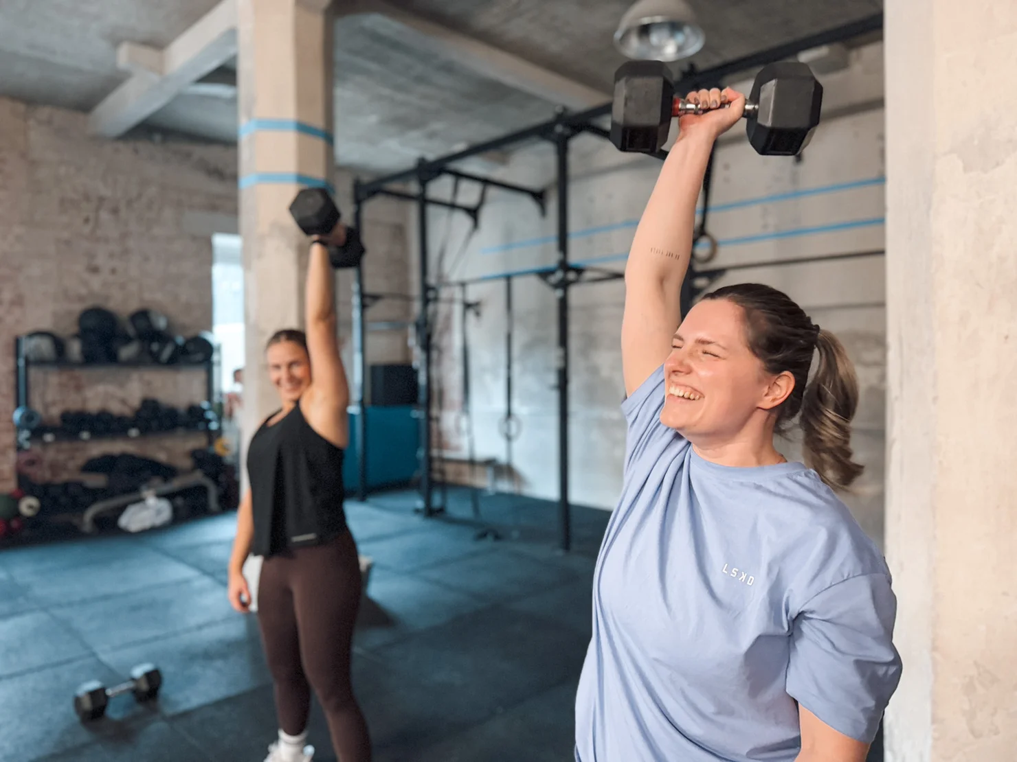 Zwei Athletinnen bei einem Workout mit Kurzhanteln