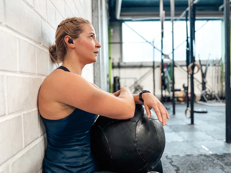 Frau, die einen Wall Sit mit einem Wall Ball macht
