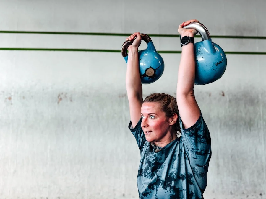 Frau, die mit Kettlebells trainiert
