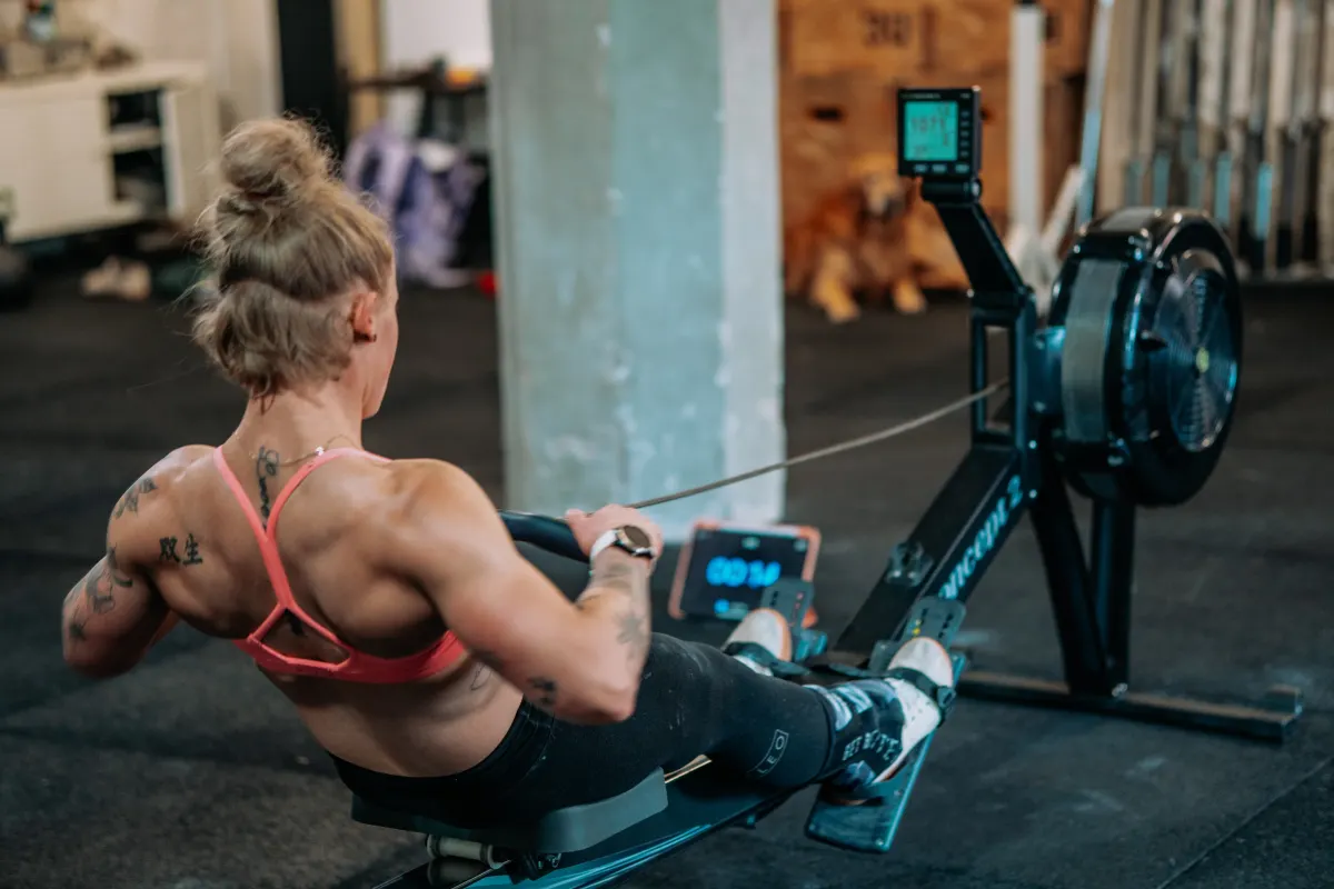 Athletin auf dem Rudergerät während eines intensiven Workouts