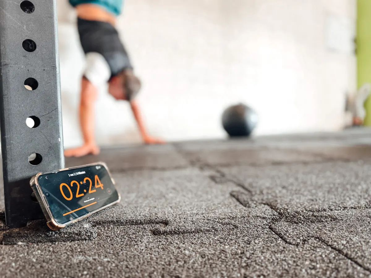 Smartphone mit laufendem Workout-Timer am Rig in einer CrossFit-Box